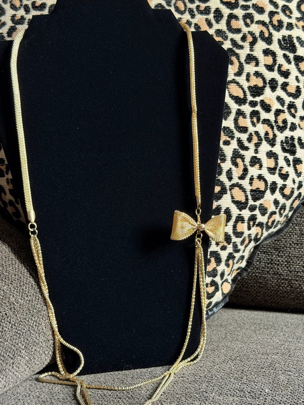 Gold toned chain with off set mesh bow
